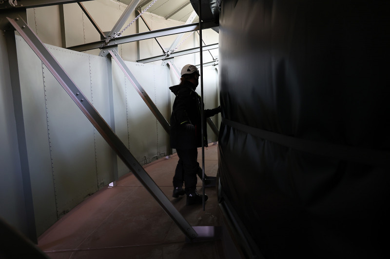 Eine Folie wird um die Rotunde auf dem Dach des Gasometers gespannt.