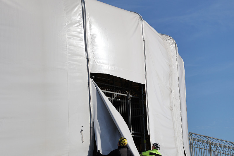 Die Einhausung der Rotunde wird von zwei Arbeitern entfernt