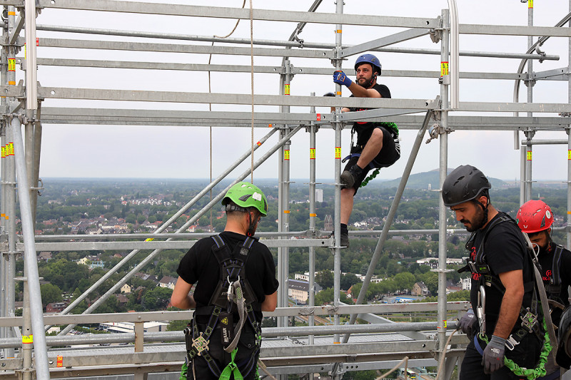 Vier Gerüstbauer auf der Dachkontruktion des Gasometers