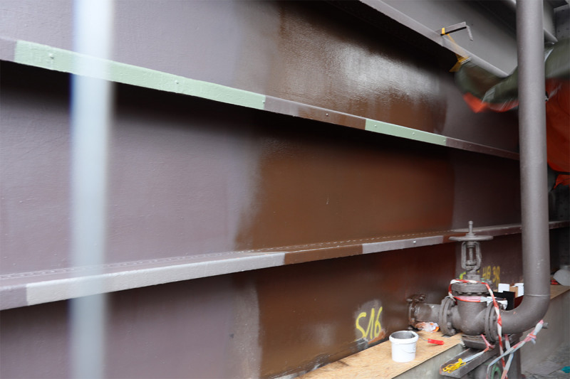 Verschiedene Grau- und Brauntöne an einer Musterfläche der Gasometer-Außenhülle.