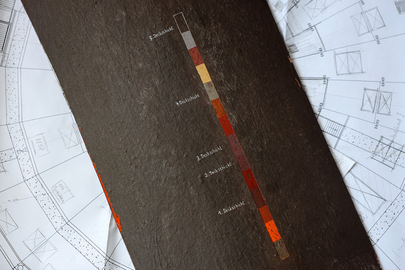 Ein Metallblech mit Freilegungstreppe liegt auf einem Bauplan des Gasomters.
