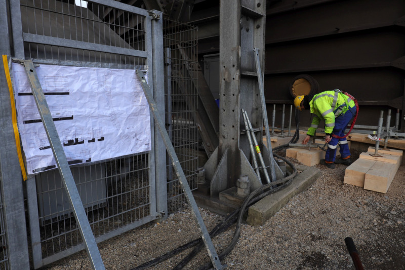 Ein Gerüstbauer beginnt mit dem Aufbau der ersten Gerüststützen.