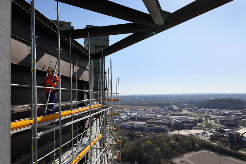 Ein Gerüstbauer arbeitet in großer Höhe am Gasometer-Fassadengerüst.