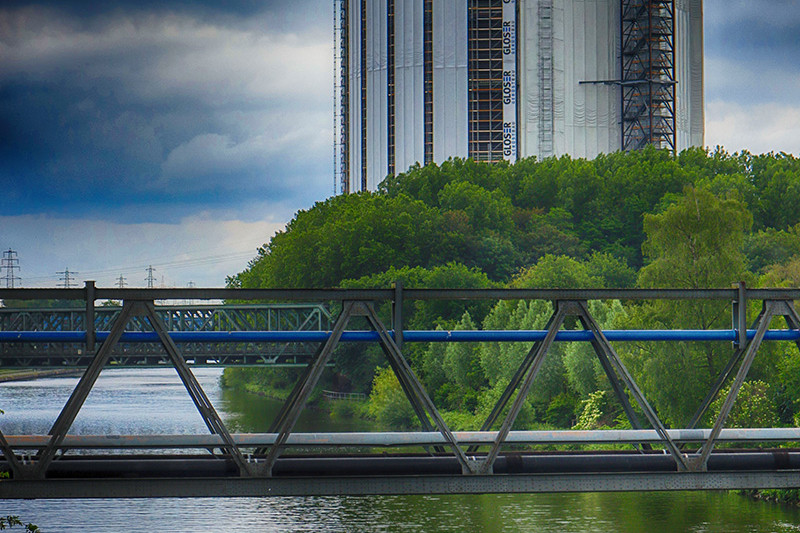 Eingerüsteter Gasometer mit einigen weißen Folienbahnen der Einhausung