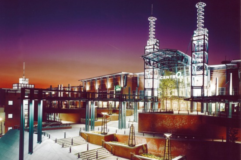 Nachtaufnahme des beleuchteten CentrO-Eingangs.