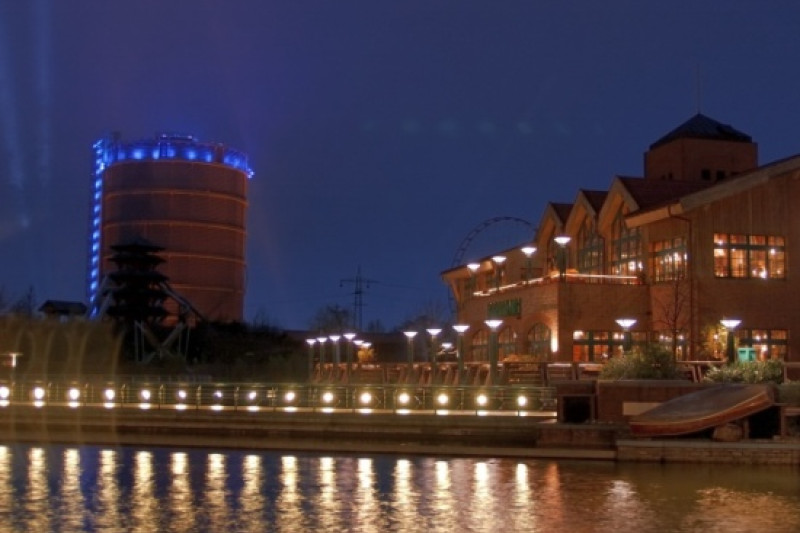 Fotografie vom beleuchteten Gasometer in Oberhausens Neuer Mitte bei Nacht.
